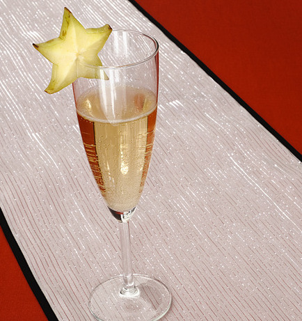 A glass of champagne garnished with a star fruit